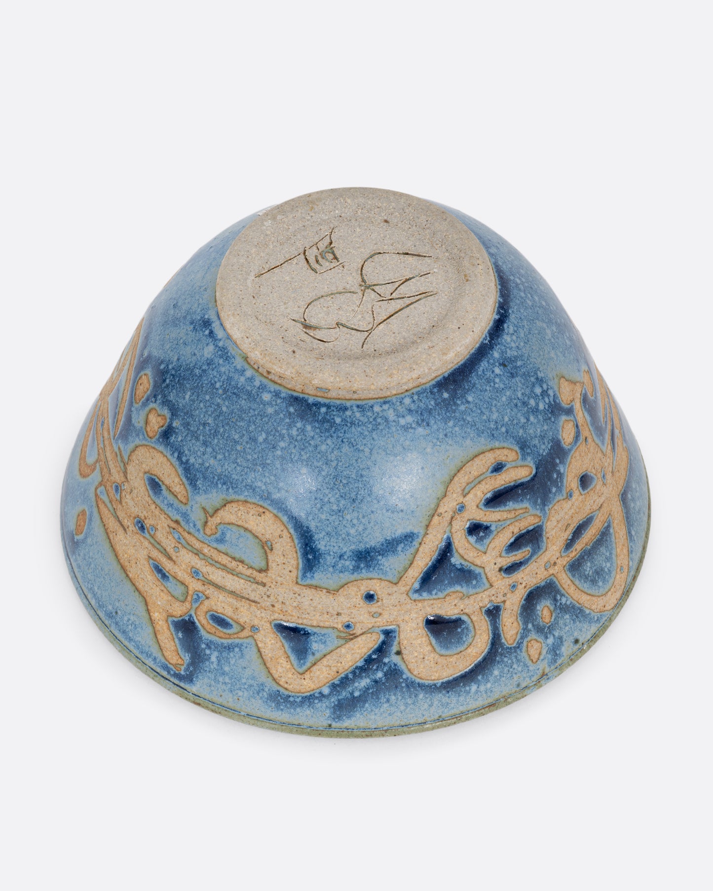 A blue ceramic bowl with brown squiggles around its middle. Shown from the bottom.