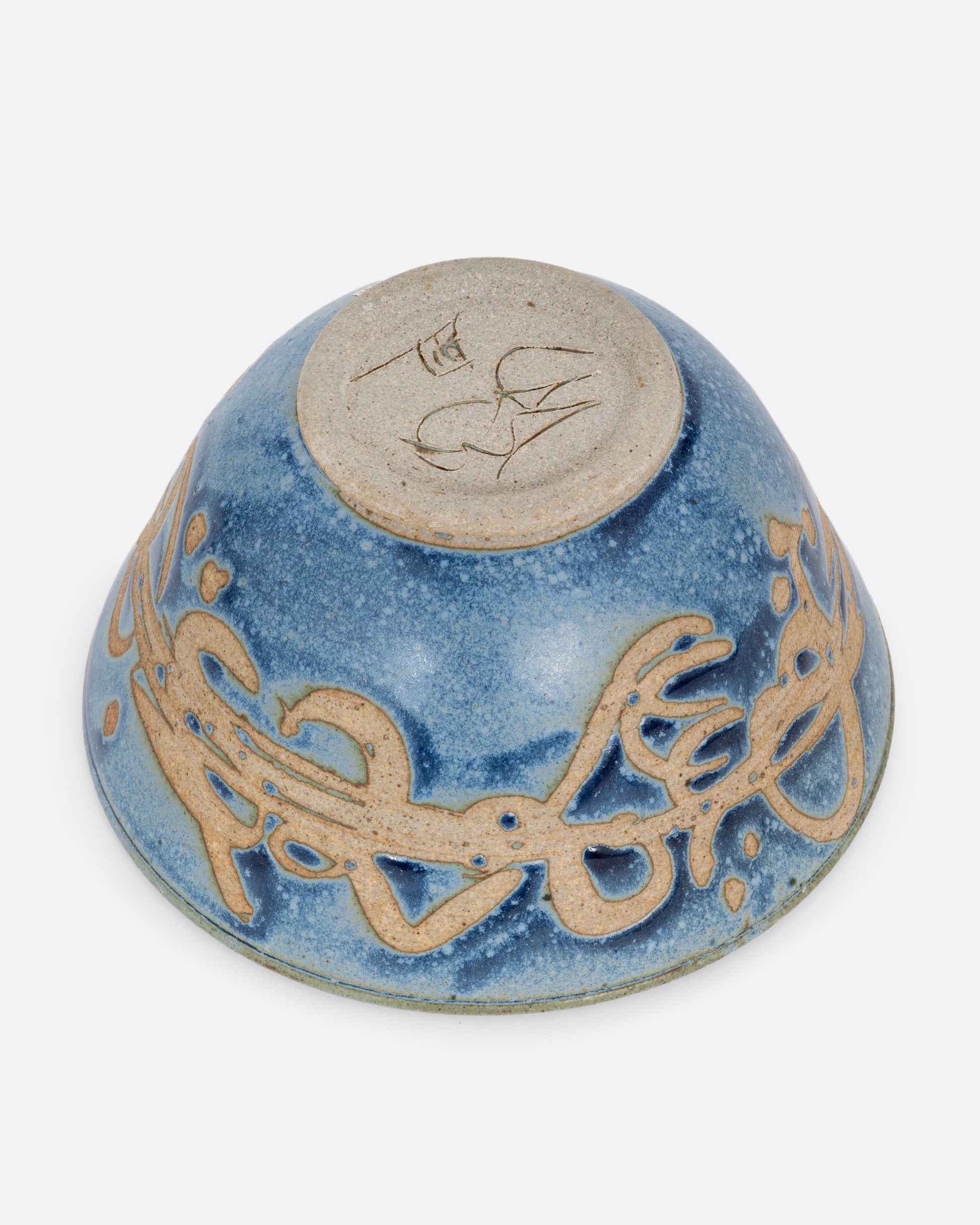 A blue ceramic bowl with brown squiggles around its middle. Shown from the bottom.