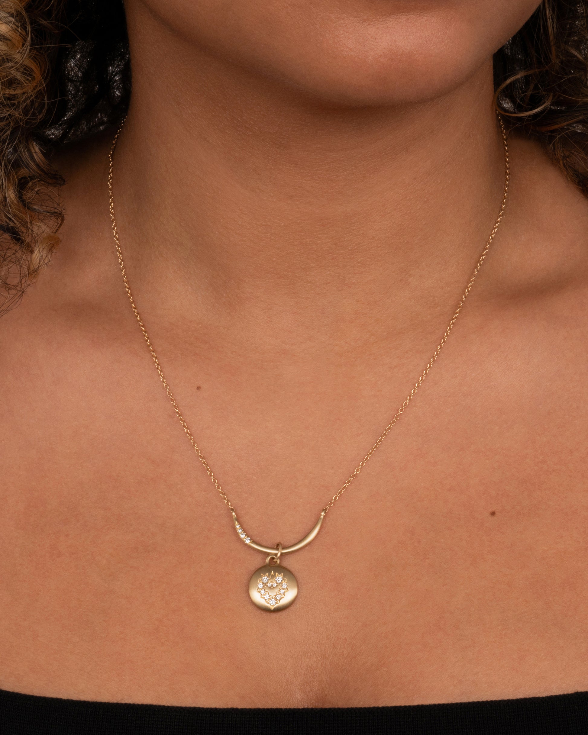 Just as lovely on its own as it is keeping your favorite charms in order. Shown worn around a neck with a circular charm with a heart of diamonds.