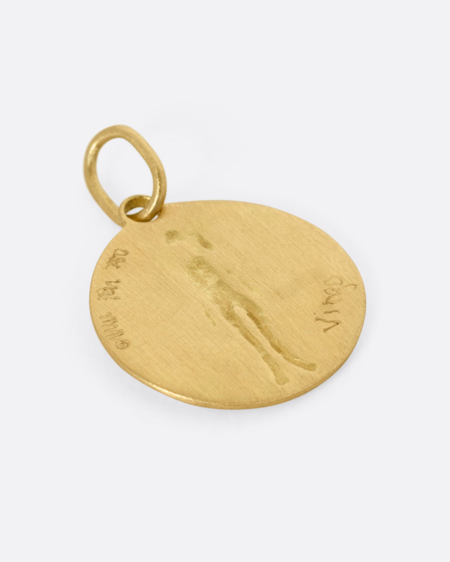 A circular yellow gold Virgo pendant with a female figure, shown from the back.