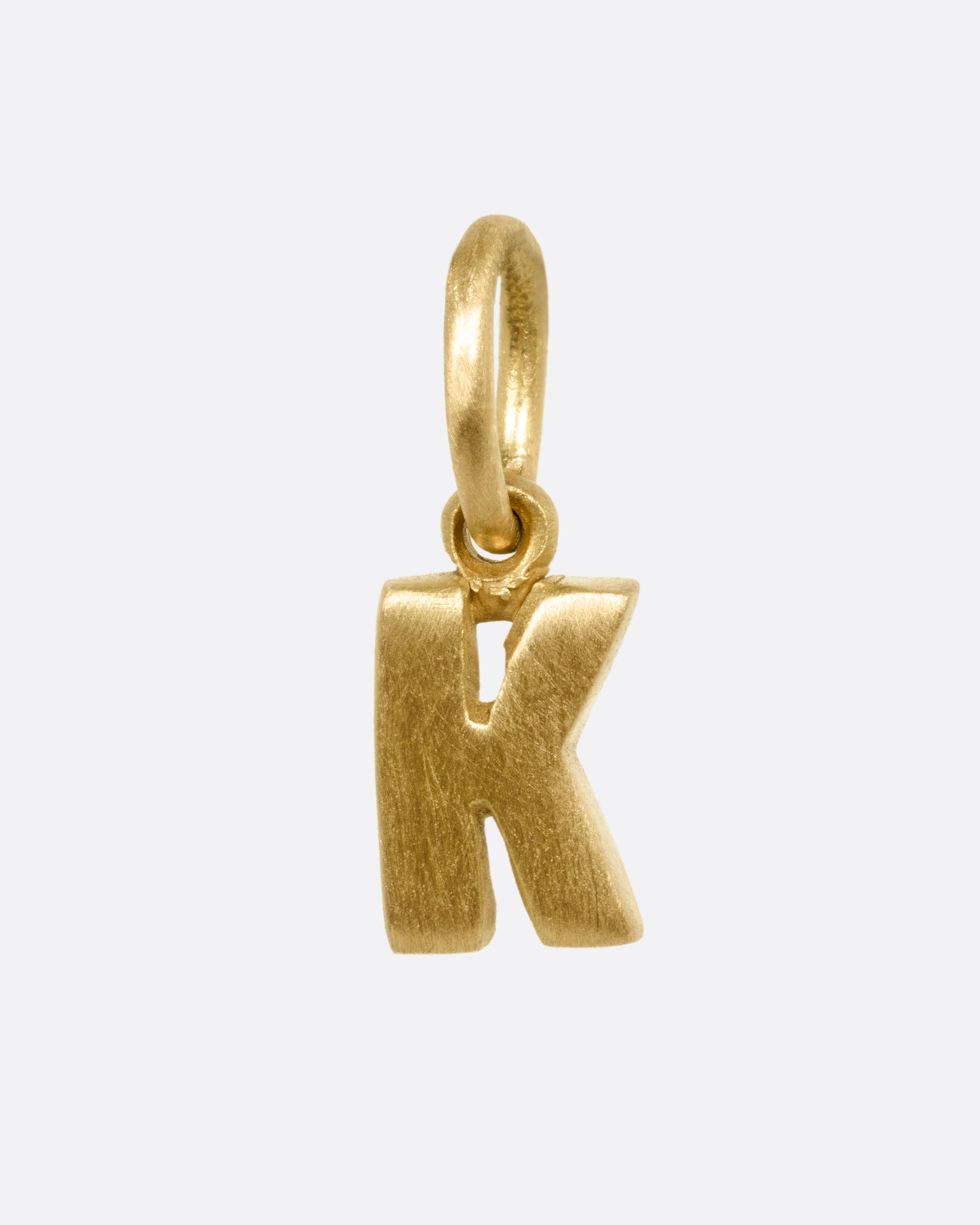 A yellow gold letter 'K' pendant shown from the front.