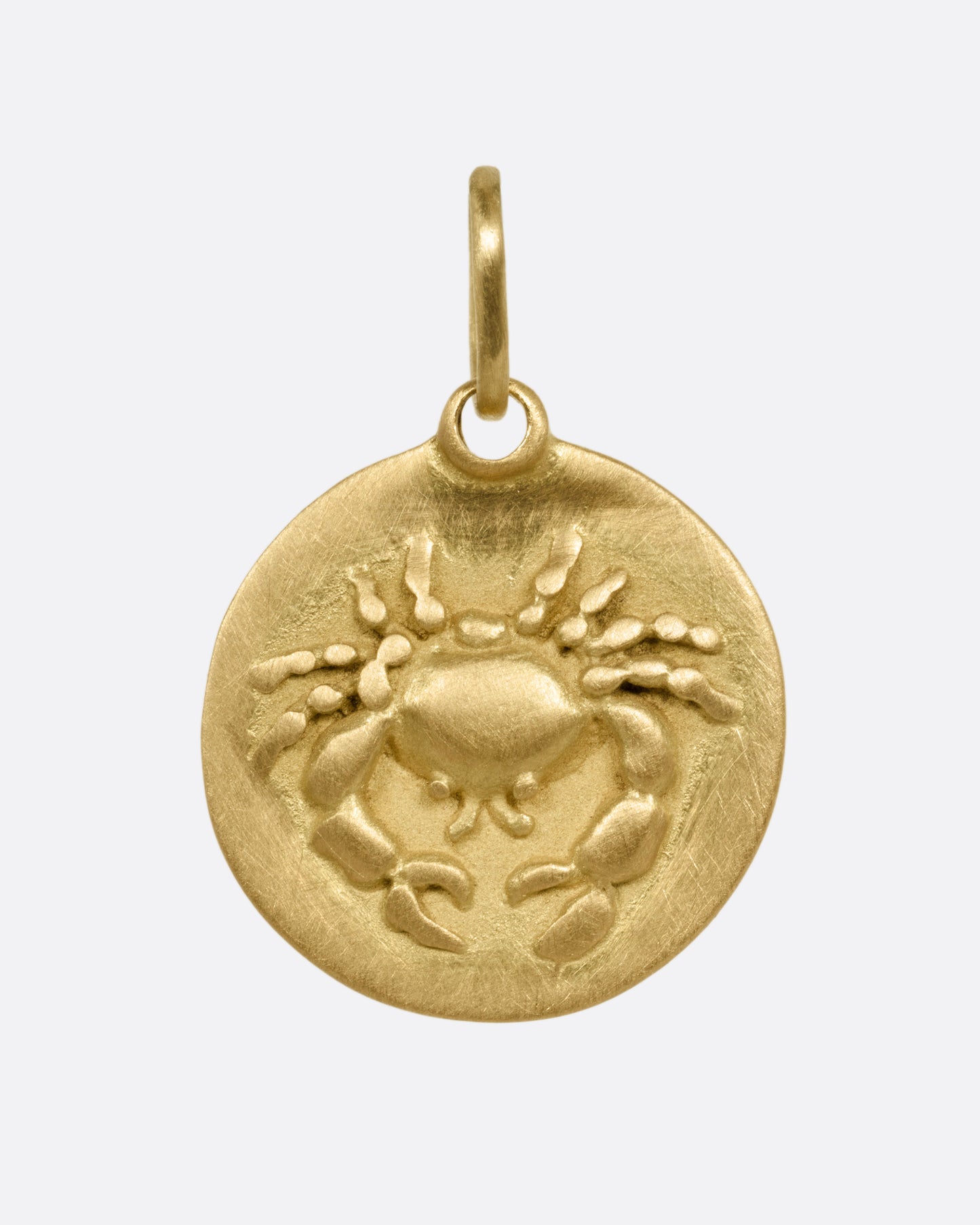 A circular yellow gold Cancer pendant with a crab on its front, shown from the front.