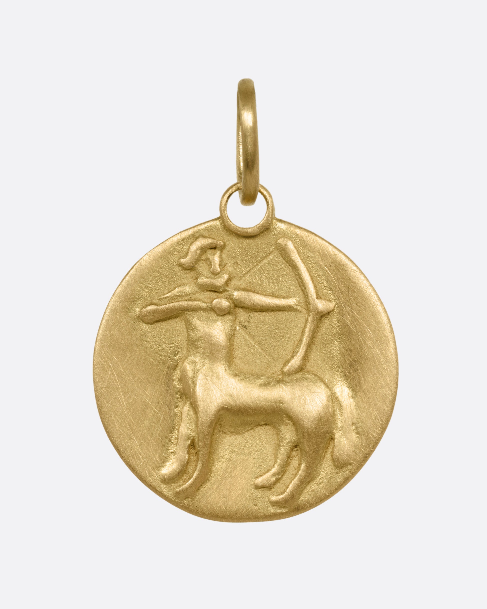 A yellow gold circular Sagittarius pendant with the archer, shown from the front.