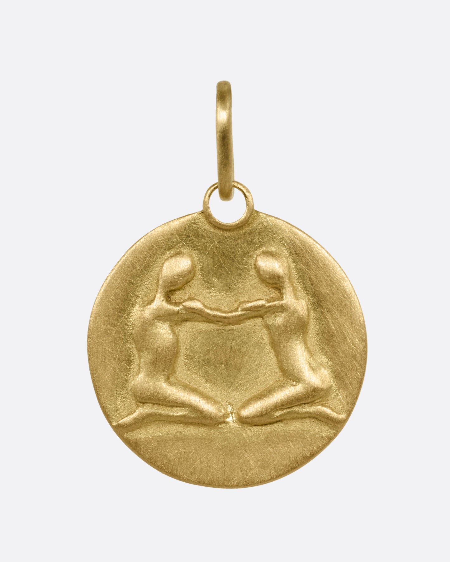 A circular yellow gold Gemini pendant with the twins, shown from the front.