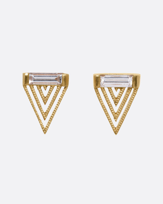 A pair of yellow gold triangular stud earrings with baguette diamonds and angular cutouts, shown from the front.