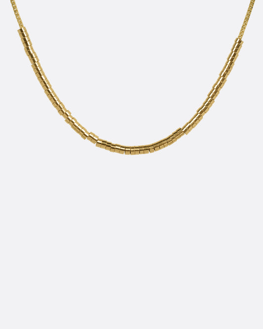 A yellow gold chain necklace with a queue of cylindrical gold beads, shown from the front.