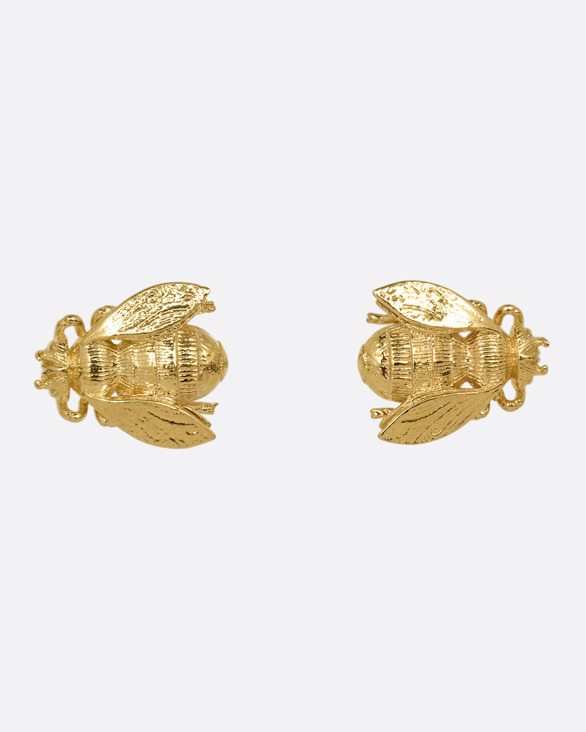 A pair of yellow gold bee earrings. Shown on their sides from the front.
