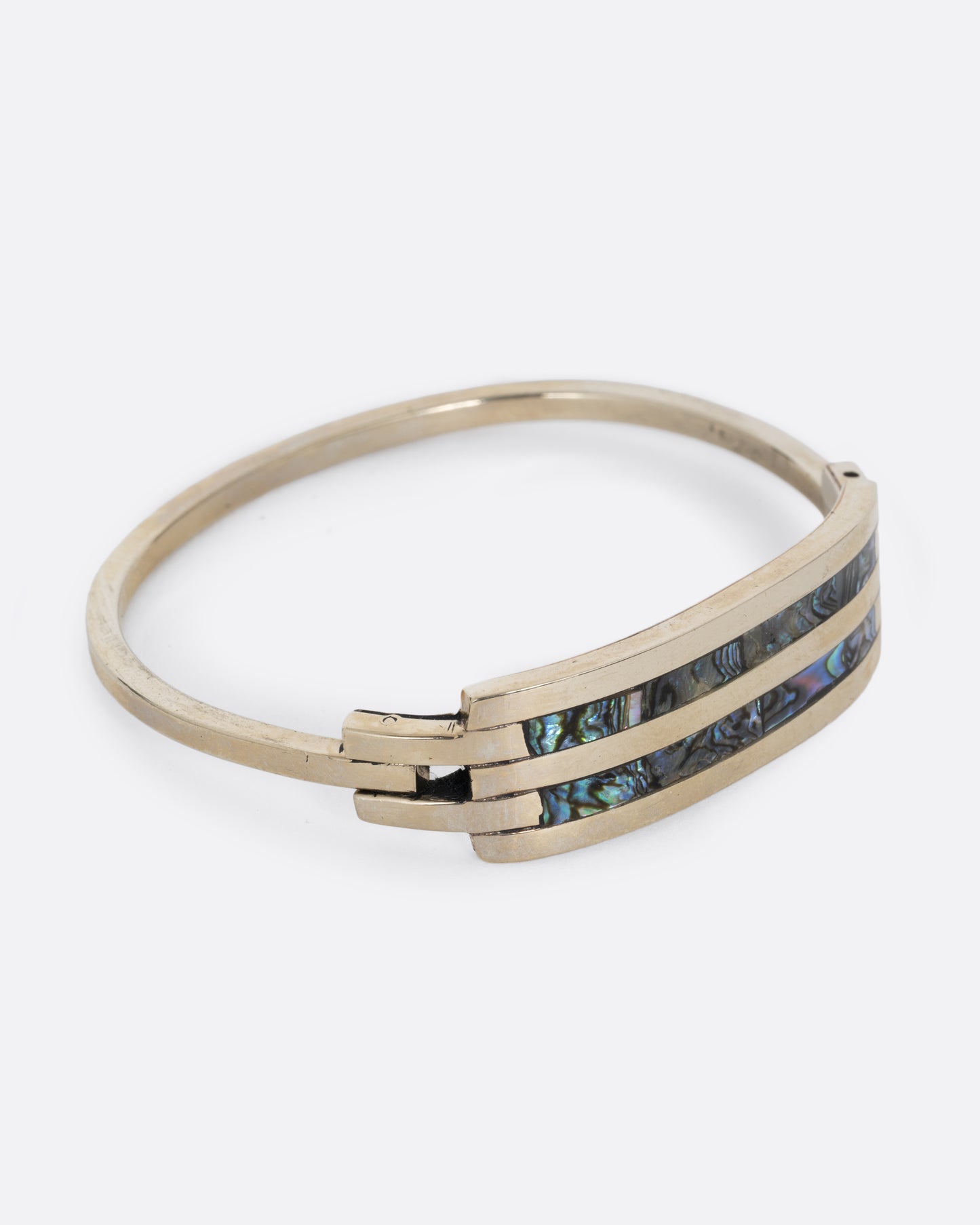 An alpaca silver bracelet with two abalone stripes and a hinged clasp. Shown from the side.