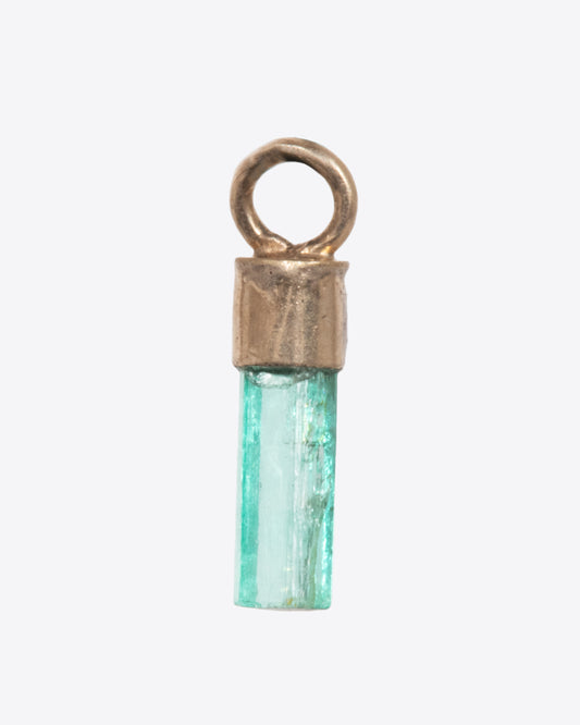 A Colombian emerald dangle in a yellow gold bail. Shown from the front.