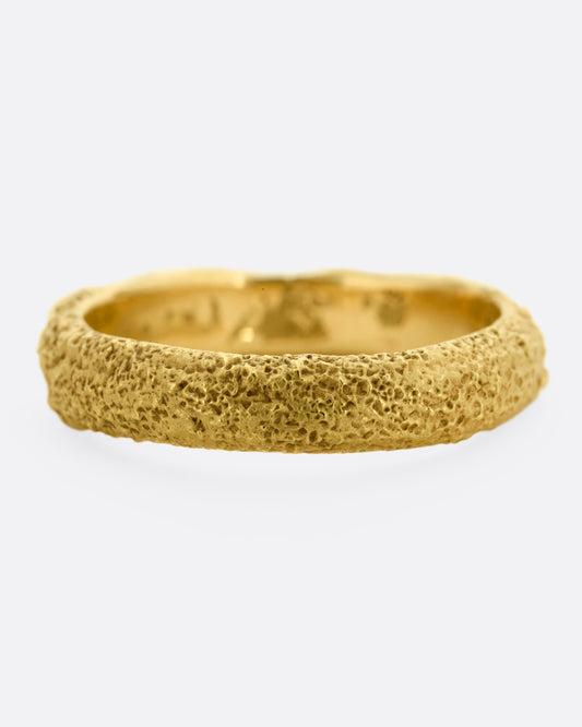A textured yellow gold band. Shown straight on.