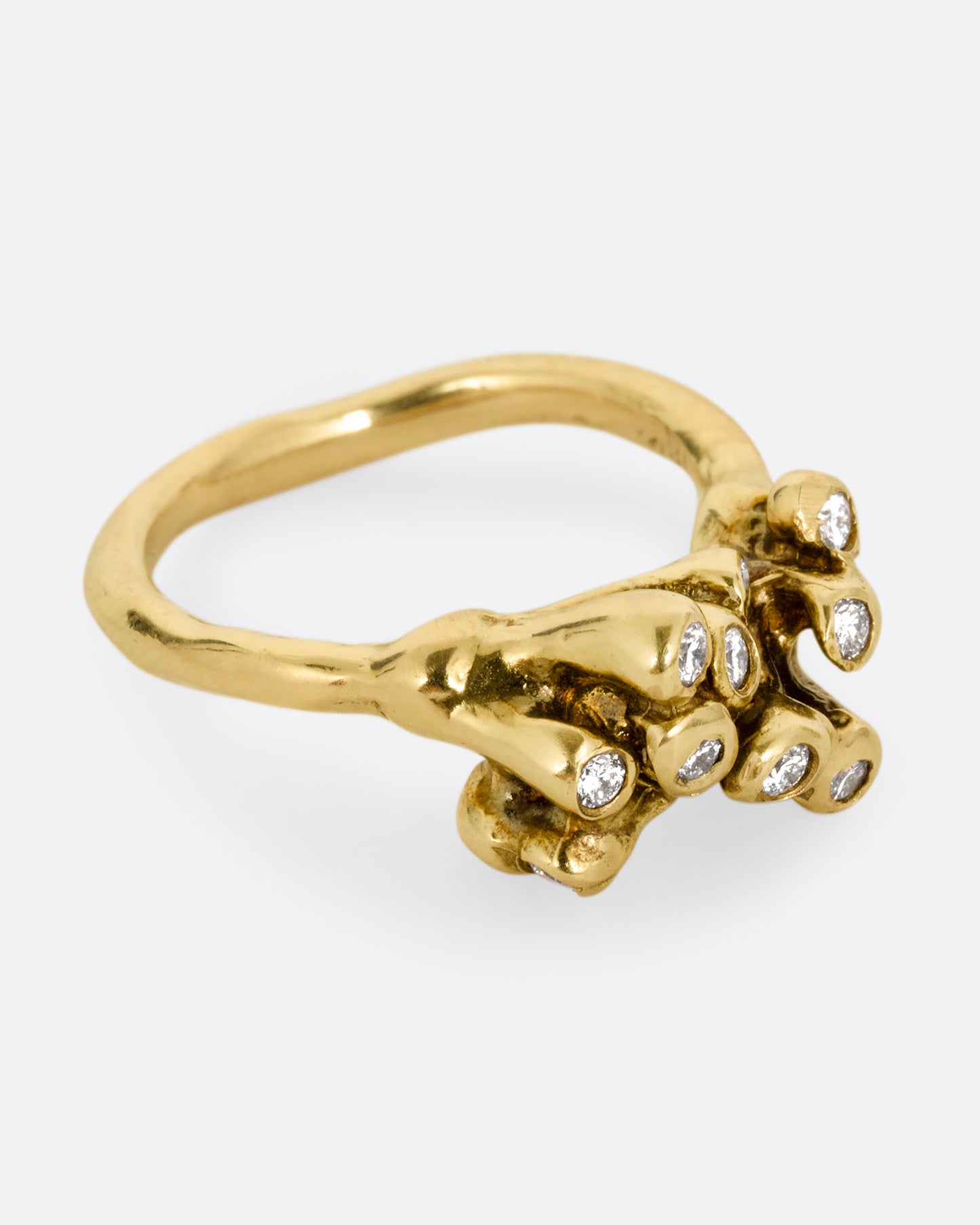 A yellow gold ring with diamond tipped anemones. Shown from the side.