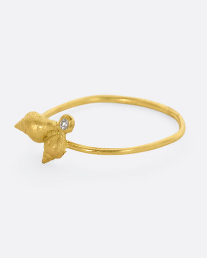 A ring with a cluster of two seashells and a diamond on a dainty band. View from the left side.
