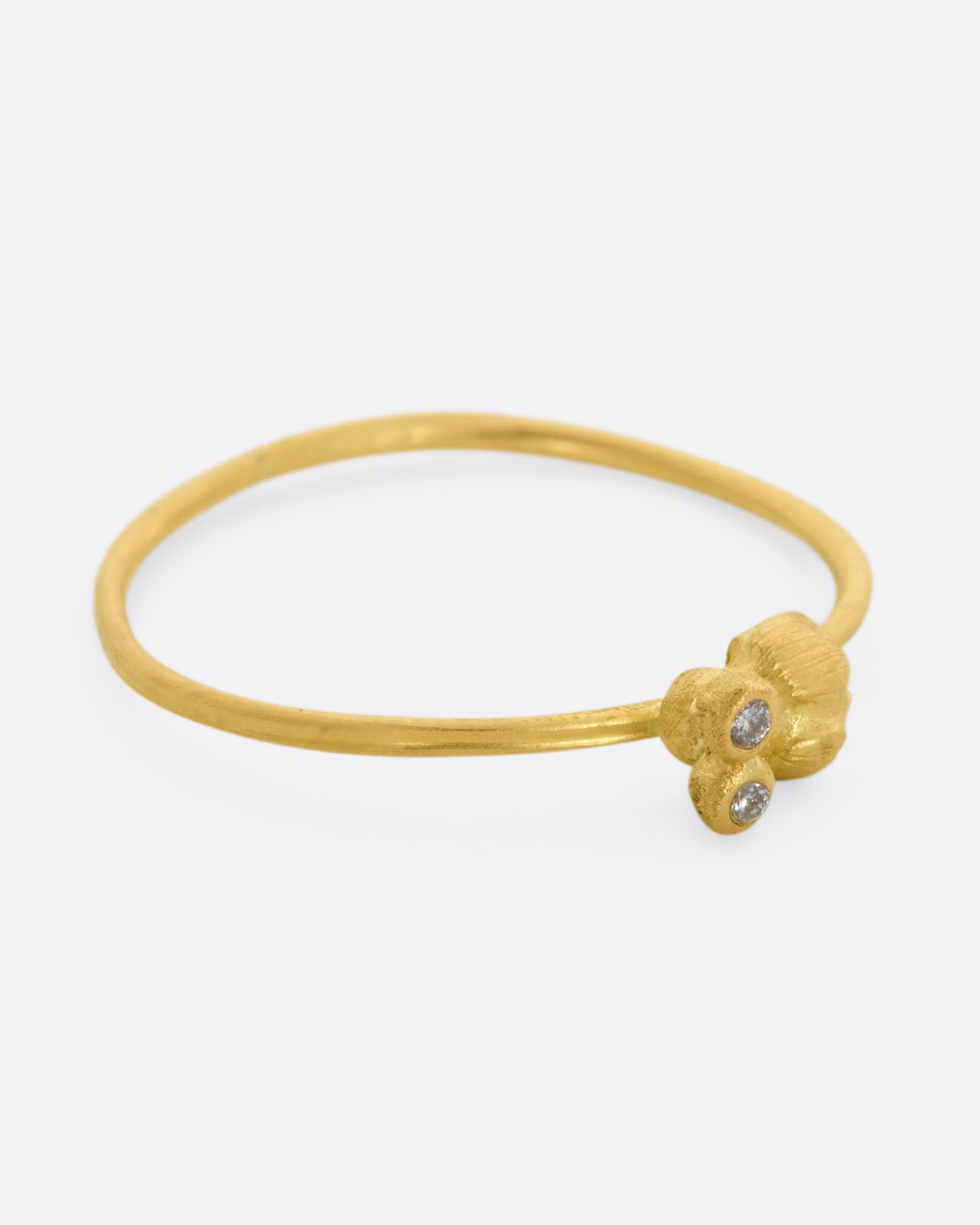 A yellow gold featuring a tiny bug with diamond eyes on a dainty band. View from the right side.