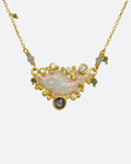 A yellow gold necklace featuring a carved opal fish surrounded by multicolor diamonds. View close up from the front.