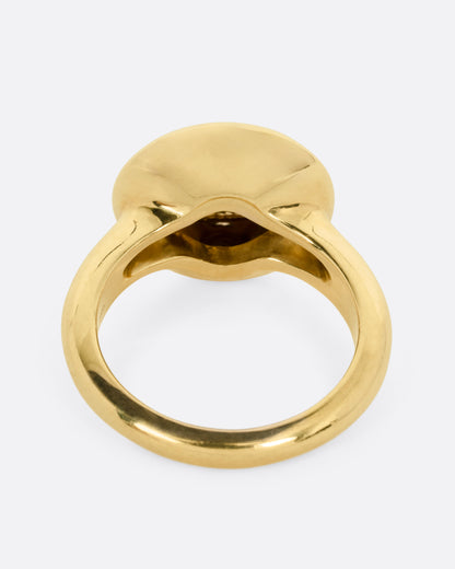 A yellow gold ring with a moon face and diamond eyes. Shown from the back.