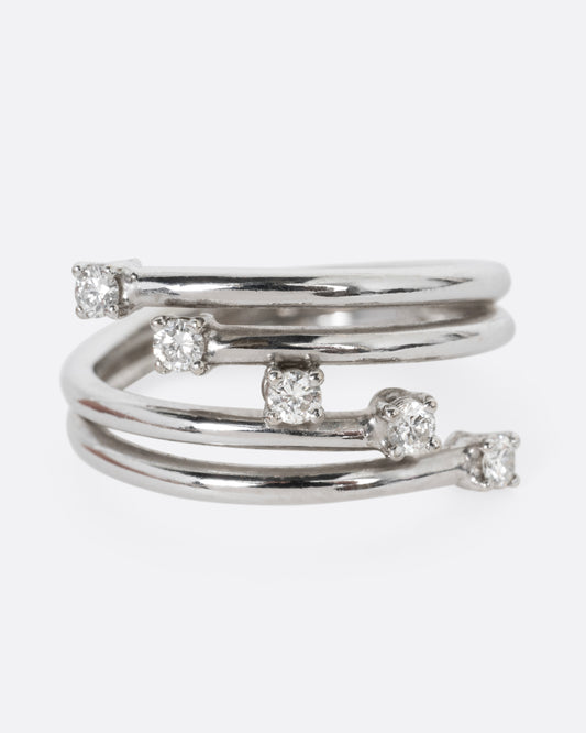 A white gold wrap ring with five diagonal prong set diamonds, shown from the front.