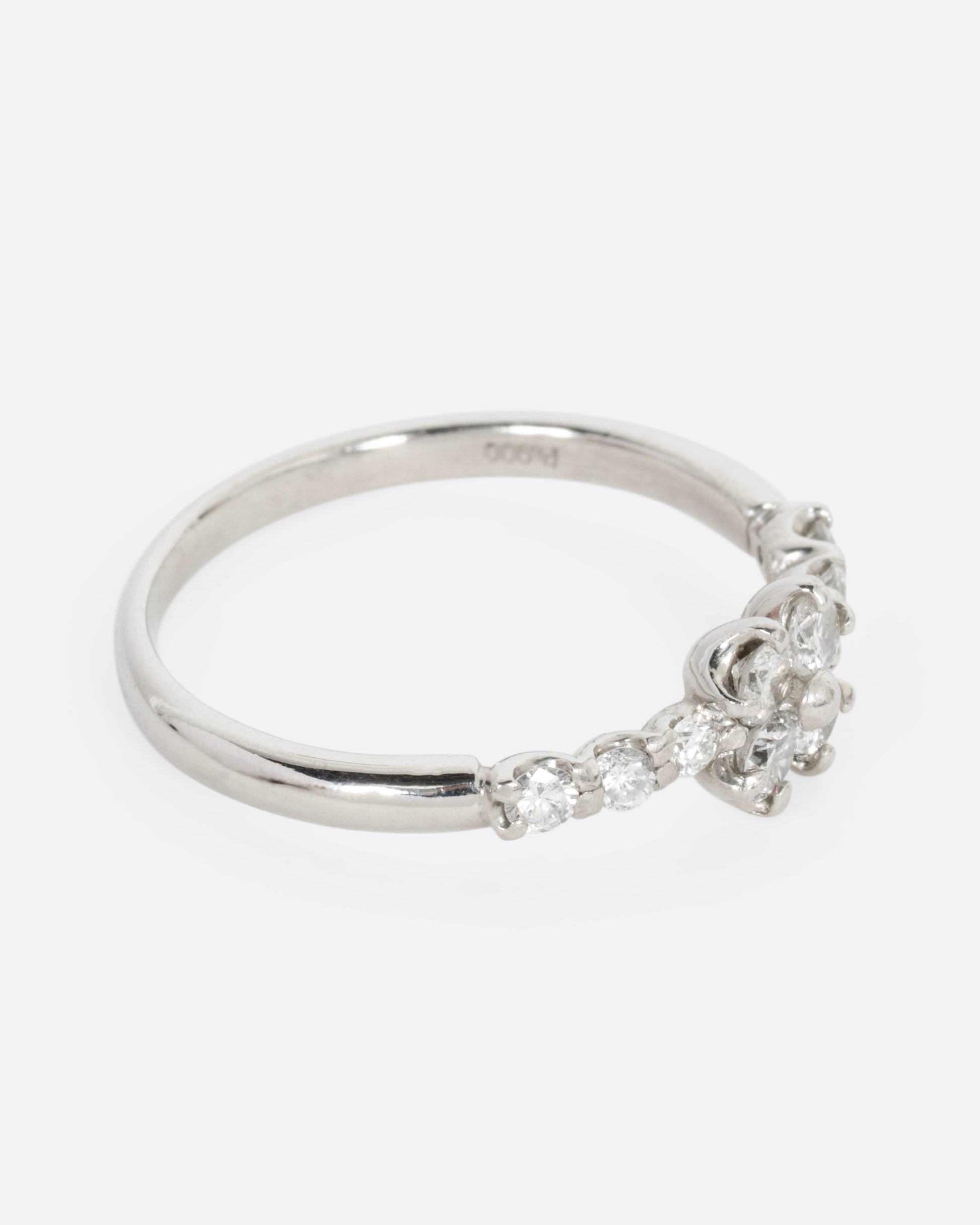 A platinum ring with an 'X' shape and diamonds, shown from the side.