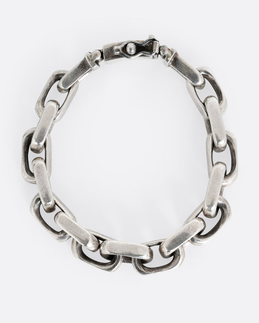 A silver oval link bracelet with a hidden clasp shown from the top.