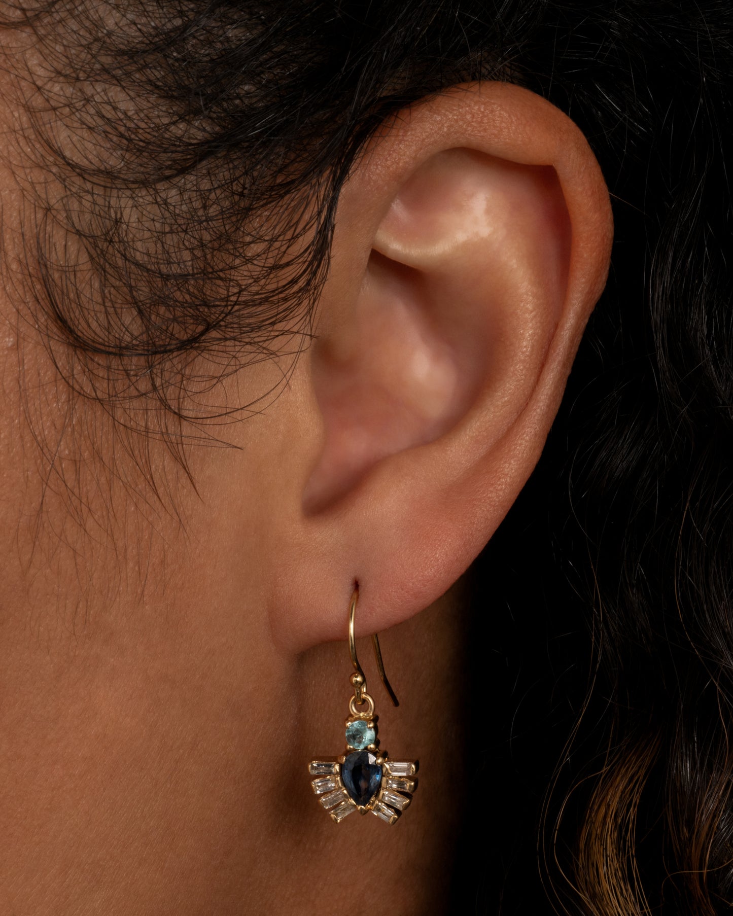 Yellow gold drop earrings with royal beetle dangles made of apatite, sapphires and diamonds. Shown worn in an ear.