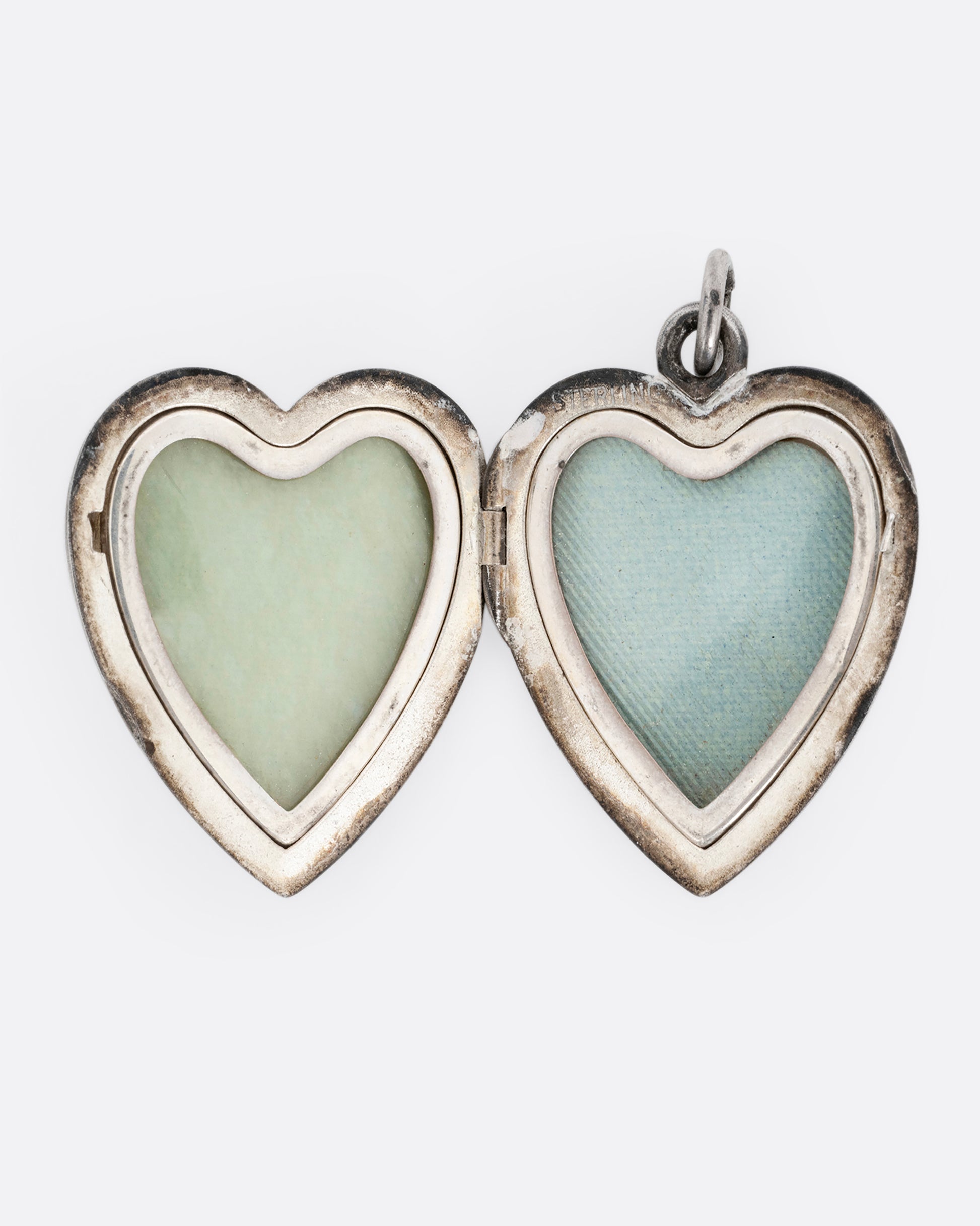 A silver heart shaped locket with two interior frames for photos. Shown open from the front.
