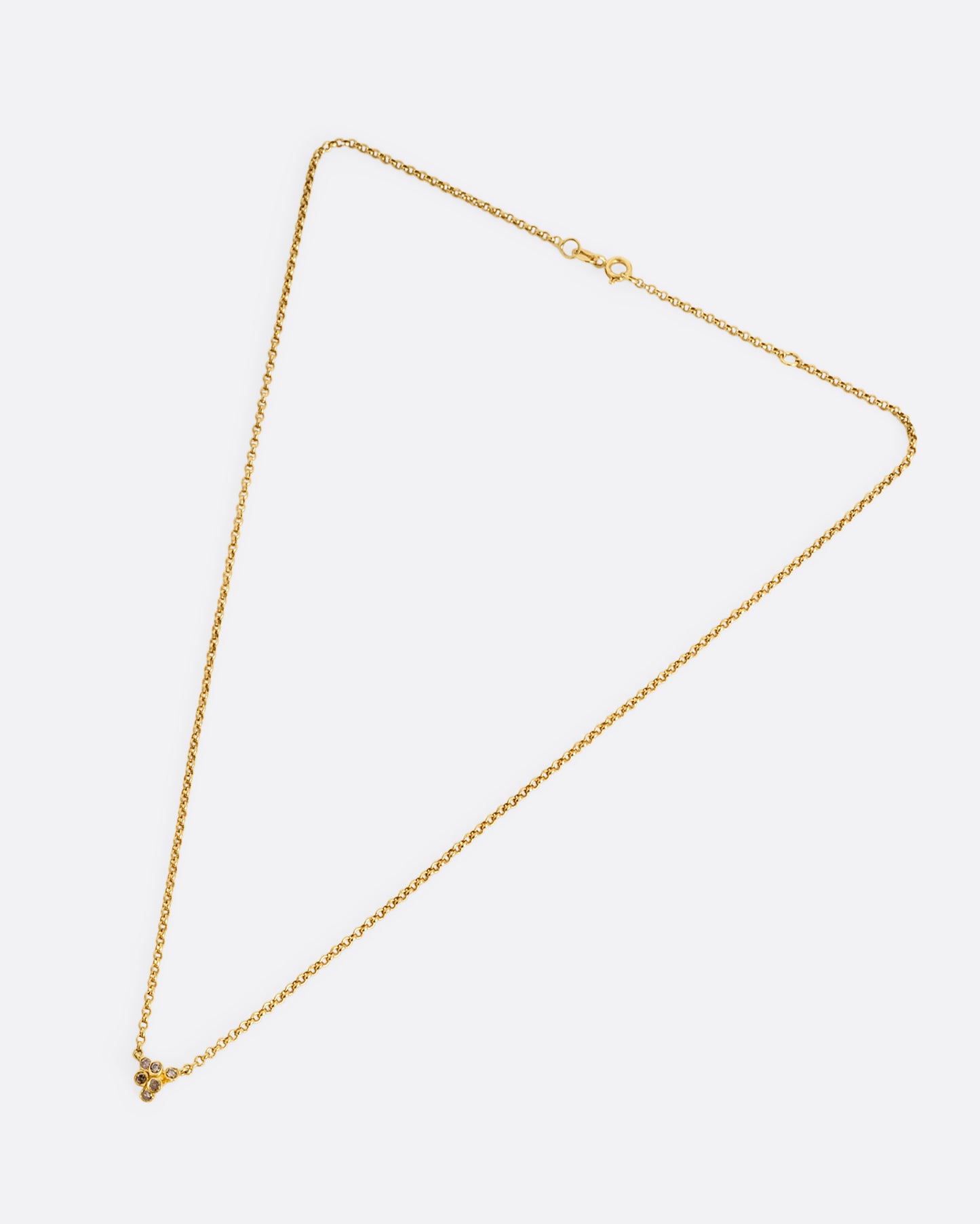 A yellow gold cable chain necklace with a central cluster of dimensional cognac diamonds. Shown from the front.