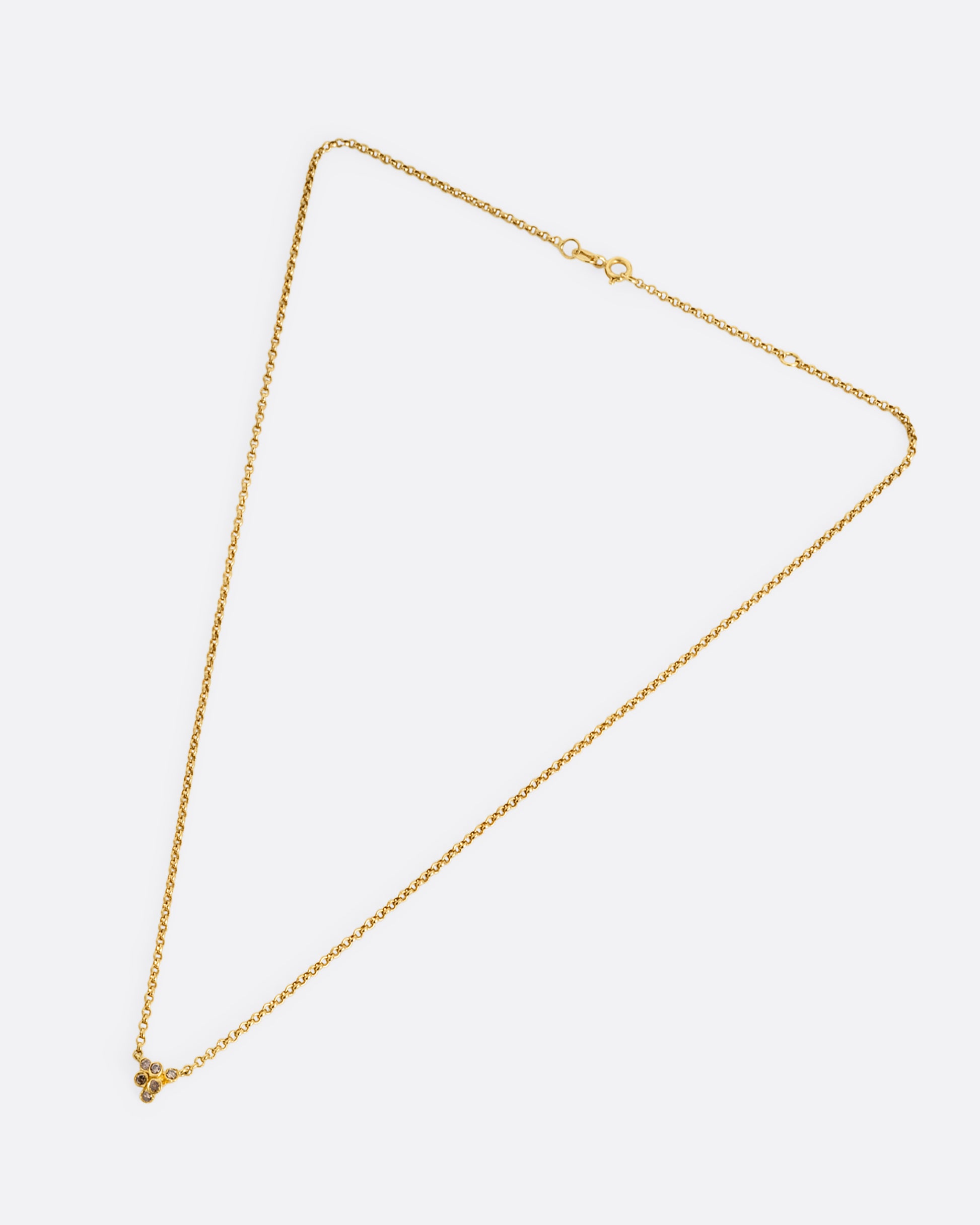 A yellow gold cable chain necklace with a central cluster of dimensional cognac diamonds. Shown from the front.