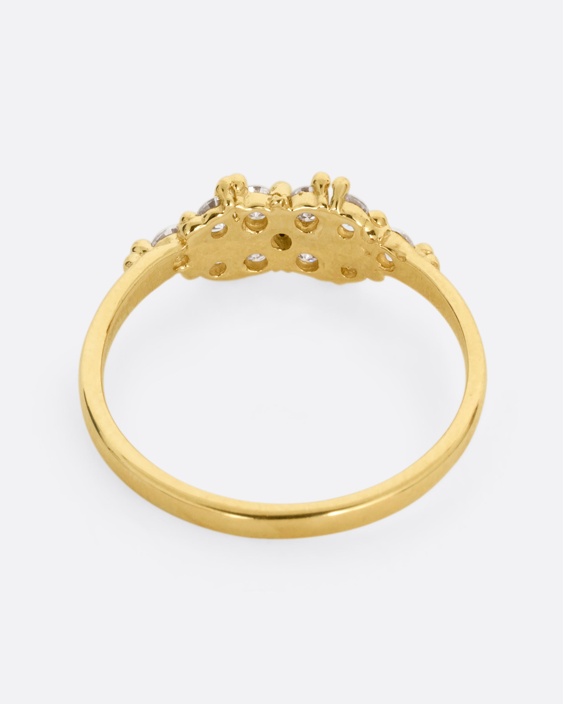 A yellow gold ring with a large cluster of diamonds and tiny gold droplets. Shown from the back.