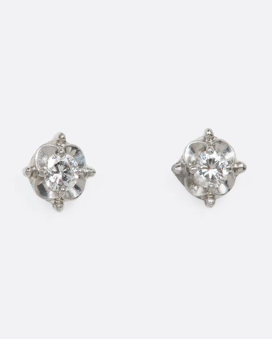 White gold solitaire studs in a floral setting. View from the front.