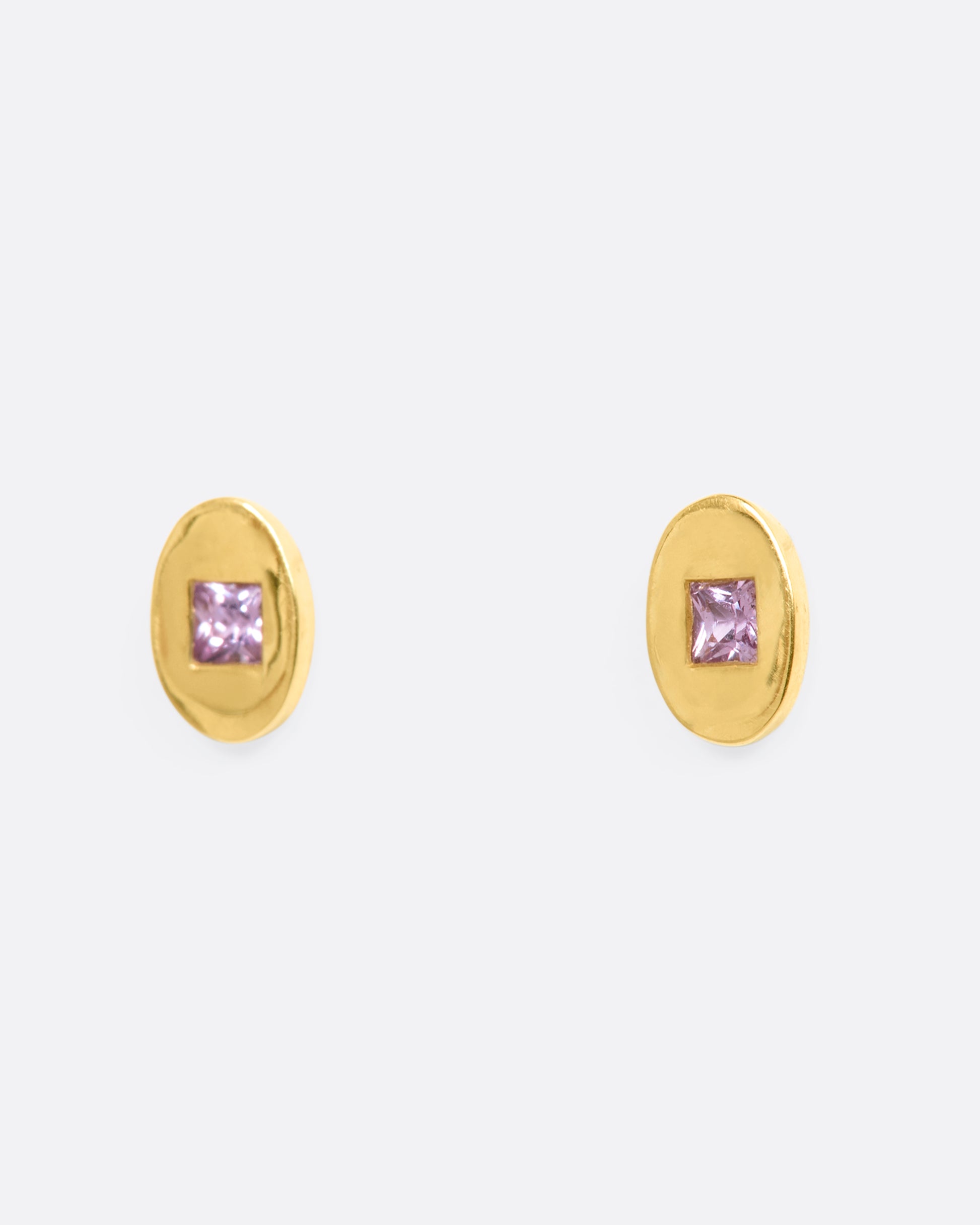 Yellow gold oval studs with princess cut pink sapphires. View from the side.