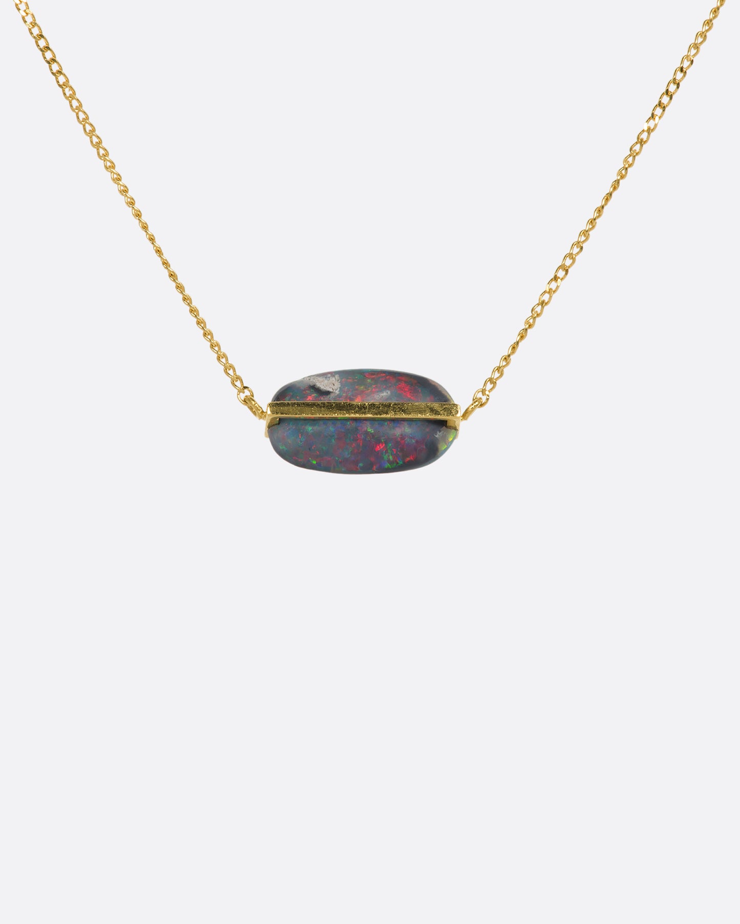 A yellow gold necklace with an oval black opal. View up close from the back.