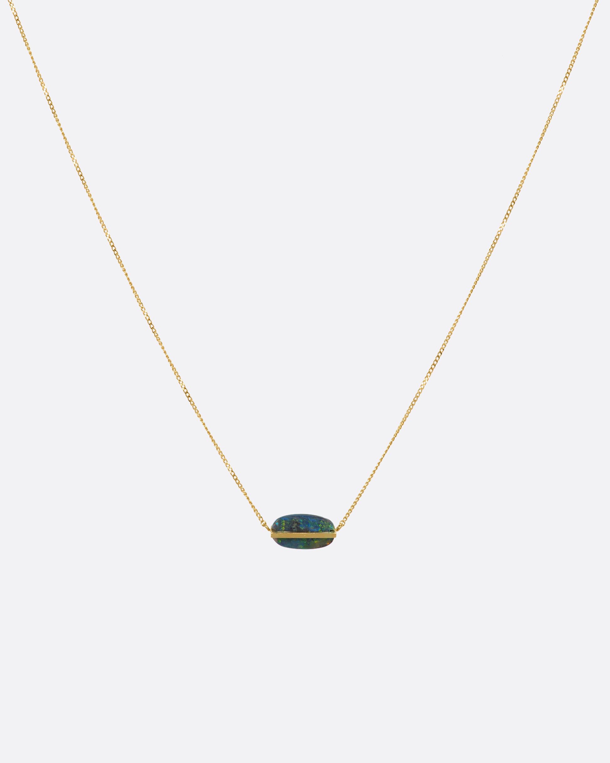 A yellow gold necklace with an oval black opal. View from the front.