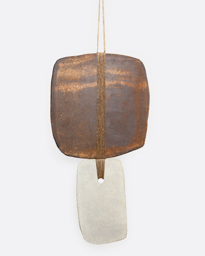 Amy Dov clay and linen wall hanging, a square glazed clay tile above a rectangle of white linen, hanging from a string