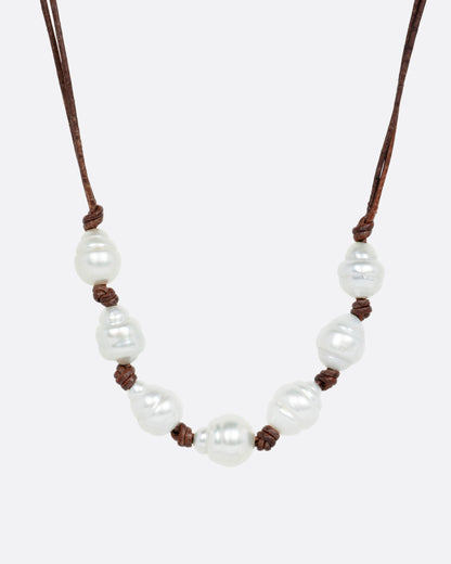 A necklace with a hand knotted leather cord and eight South Sea pearls, shown from the front.