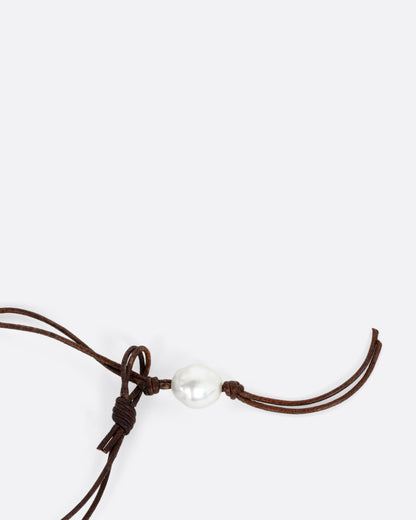 The clasp of a necklace with a hand knotted leather cord and eight South Sea pearls.