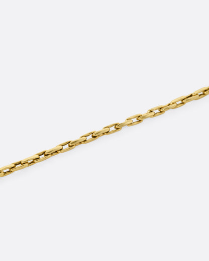 A close up of a A yellow gold box chain with elongated links.