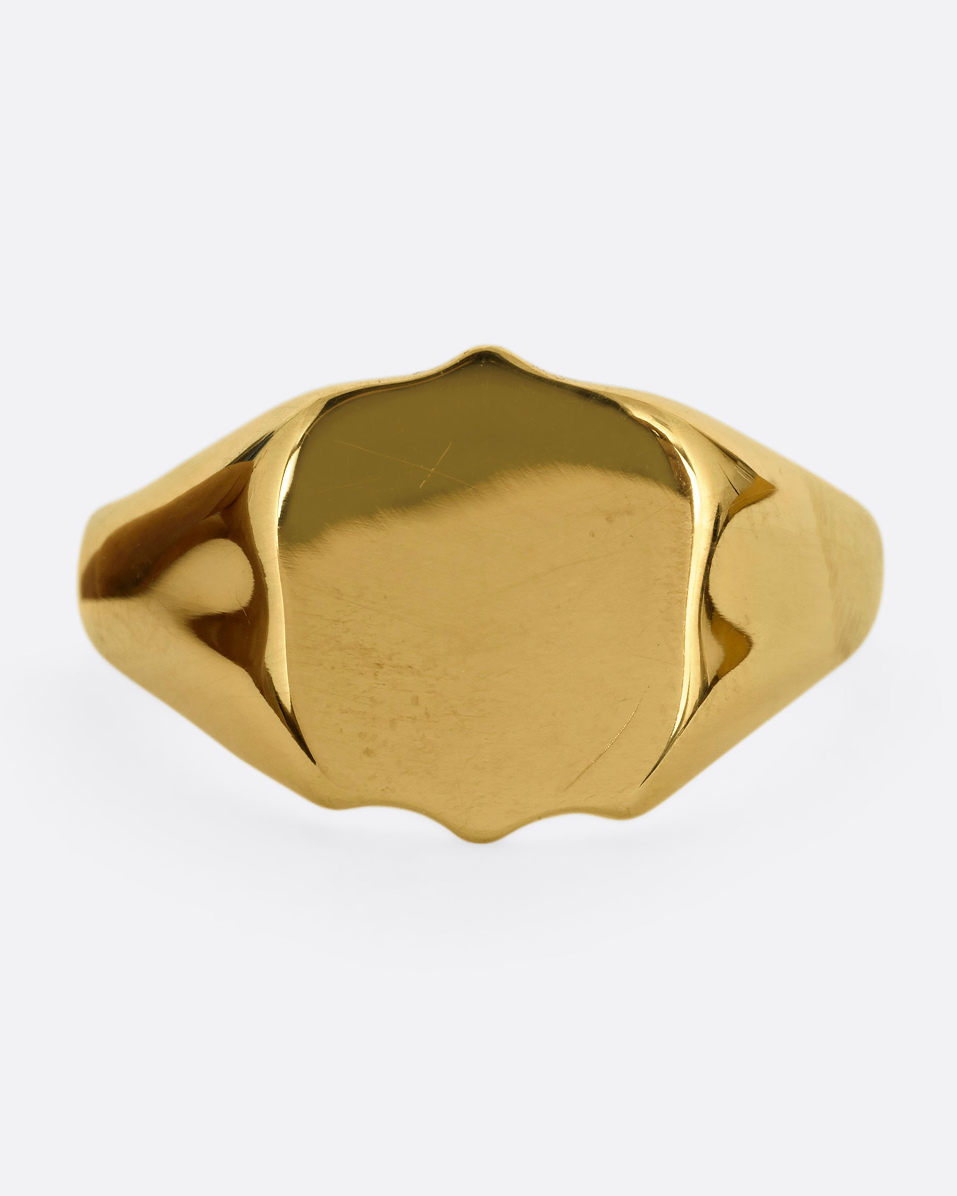 A yellow gold shield shaped signet ring. Shown from the front.