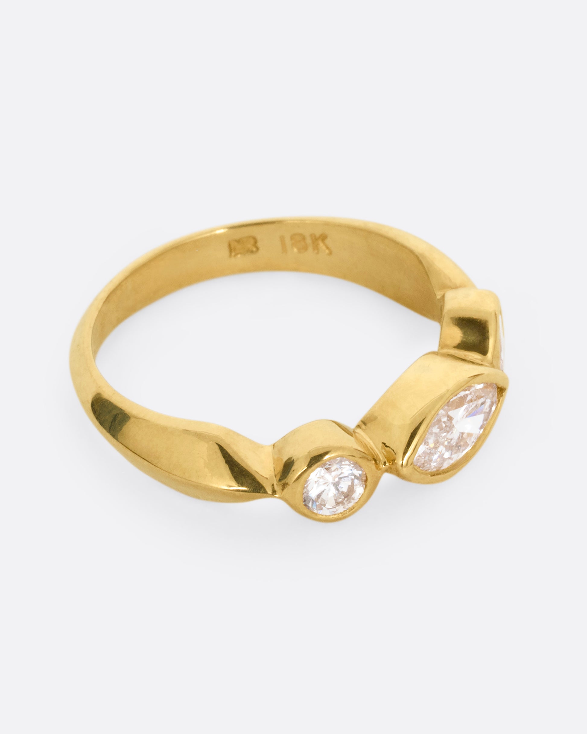 A yellow gold ring with three diamonds shown from the side.