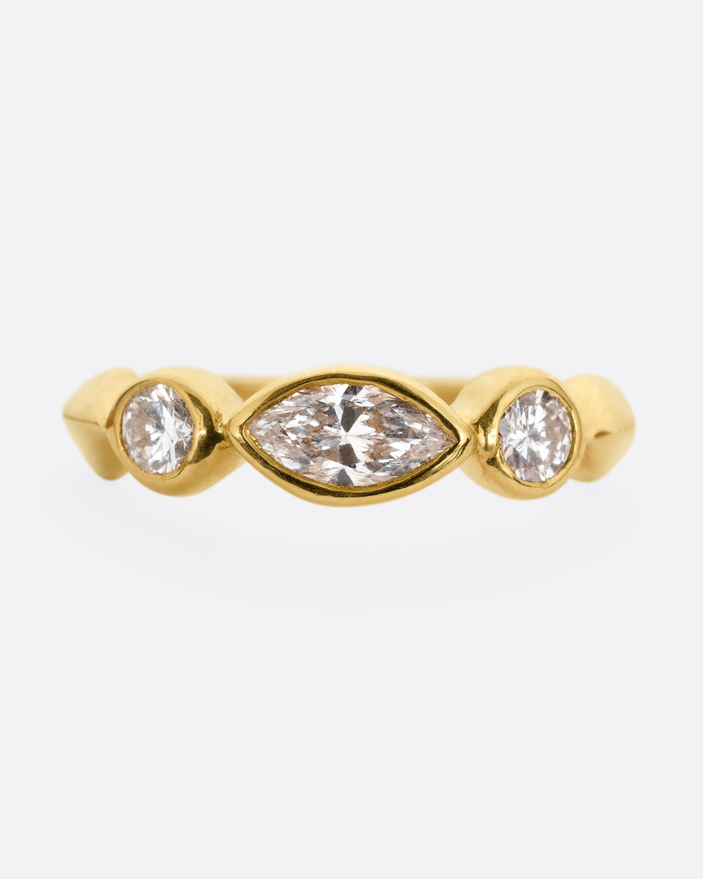 A yellow gold ring with three diamonds shown from the front.