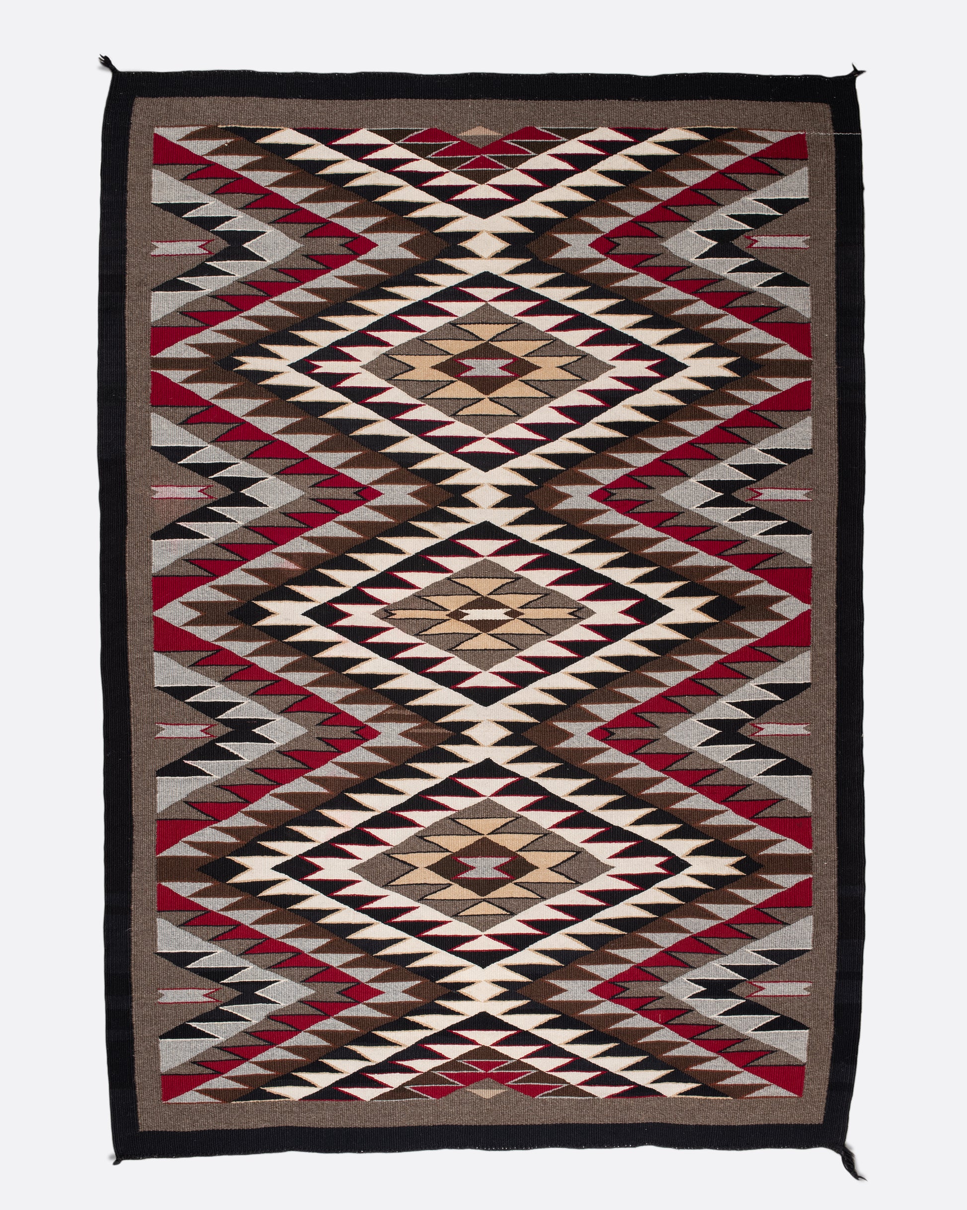 A hand spun Navajo Eye Dazzler rug with three serrated diamonds and a double-layer border