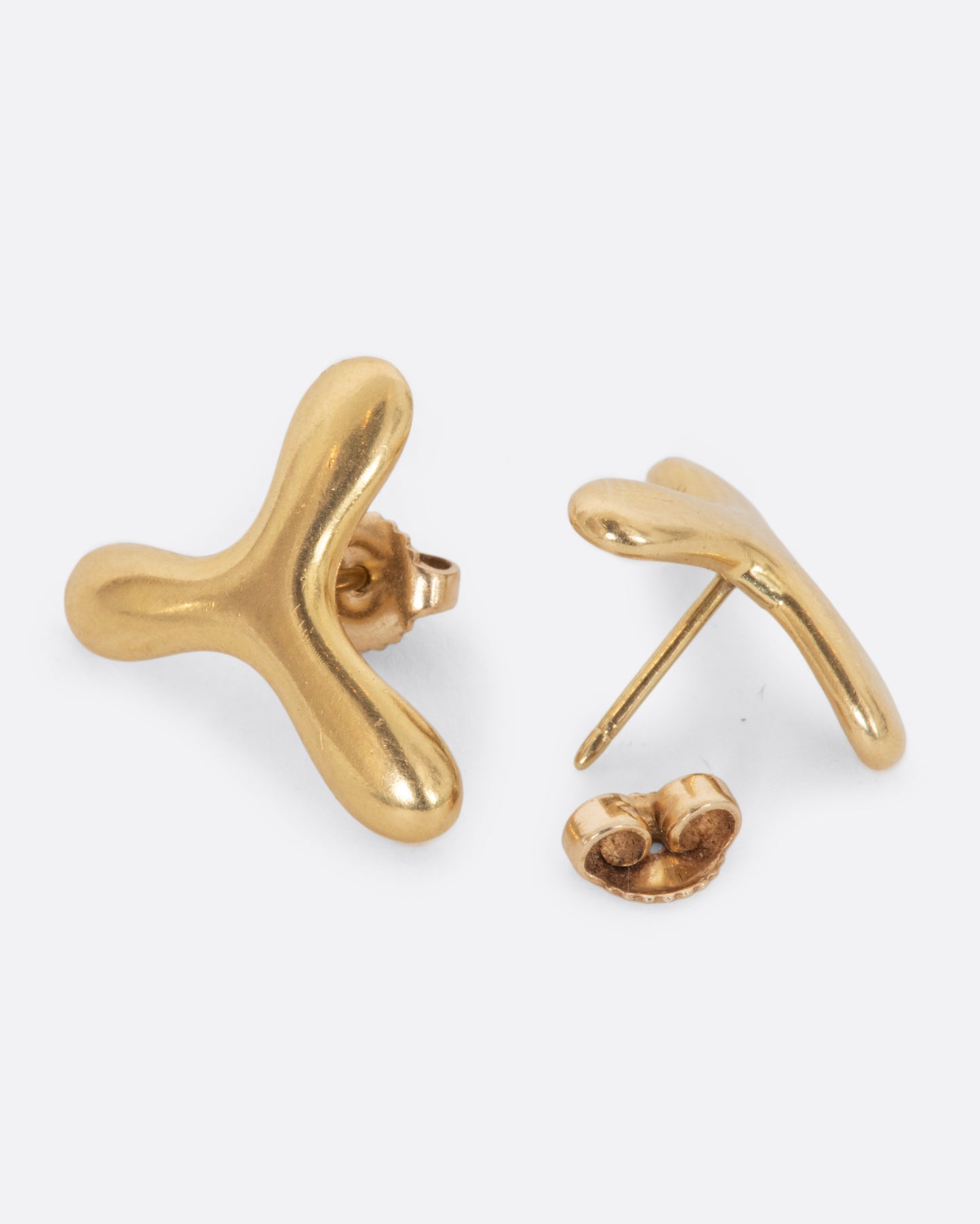 Yellow gold Tiffany three point studs. View laying flat.