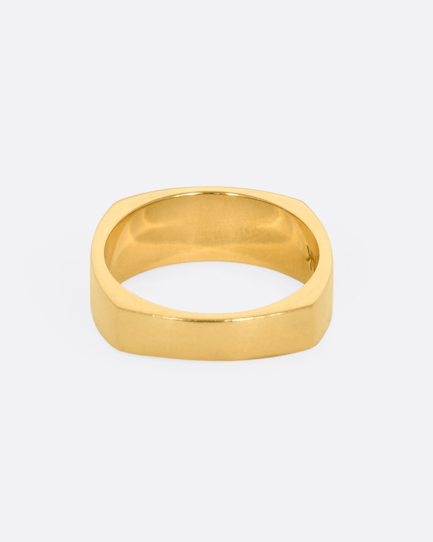 A yellow gold squared band with a star etching on the front. View from the back.