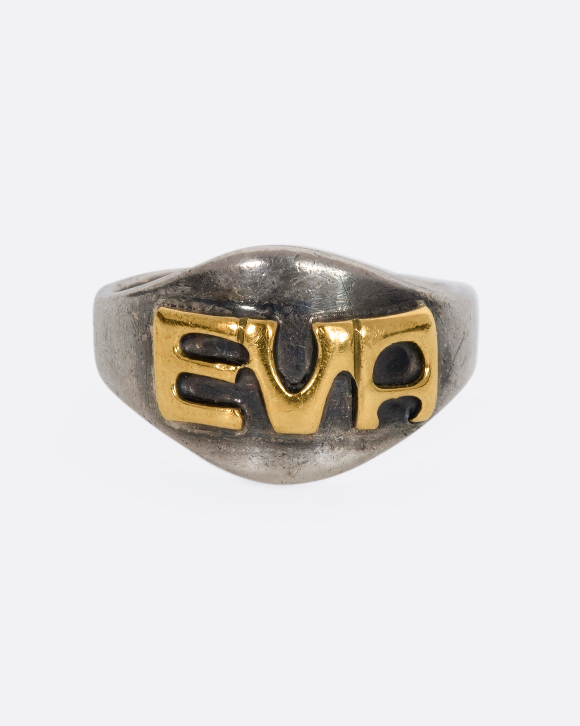 A sterling silver signet ring with the letters "EVA". View from the front.