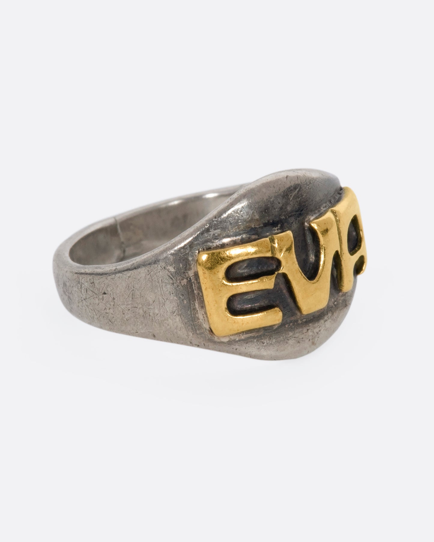 A sterling silver signet ring with the letters "EVA". View from the side.