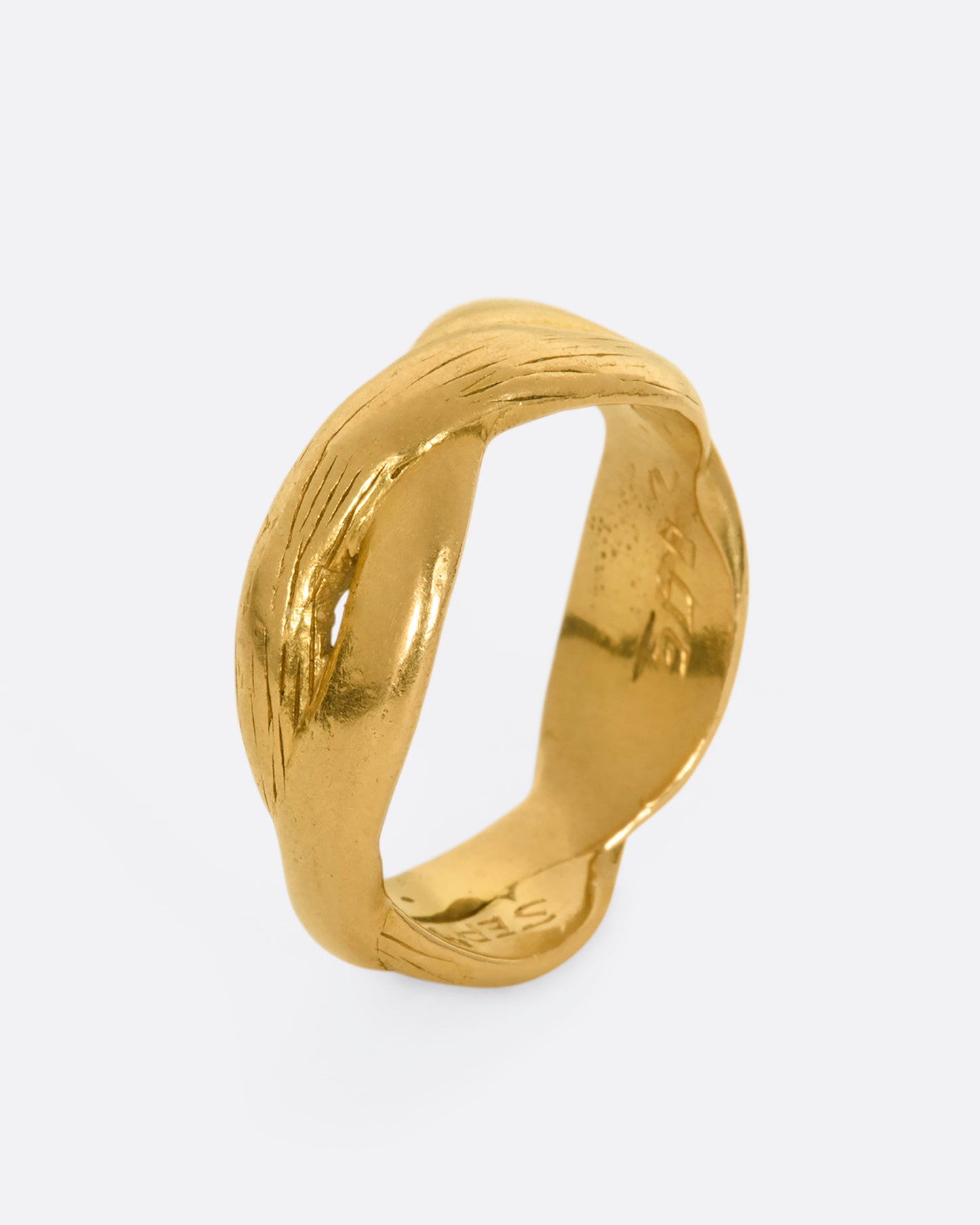 A yellow gold twisted band with engraving.