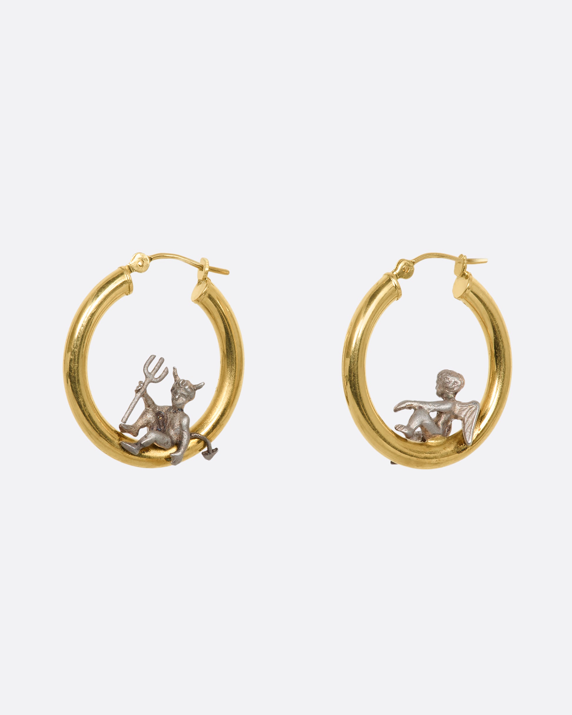 A pair of hoop earrings with an angel and devil perched on the inside. View from the back.