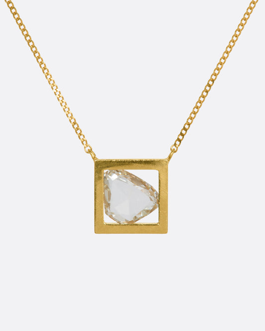 A yellow gold square fixed pendant frame holds a rose cut diamond slice hanging from a chain. View from the front.