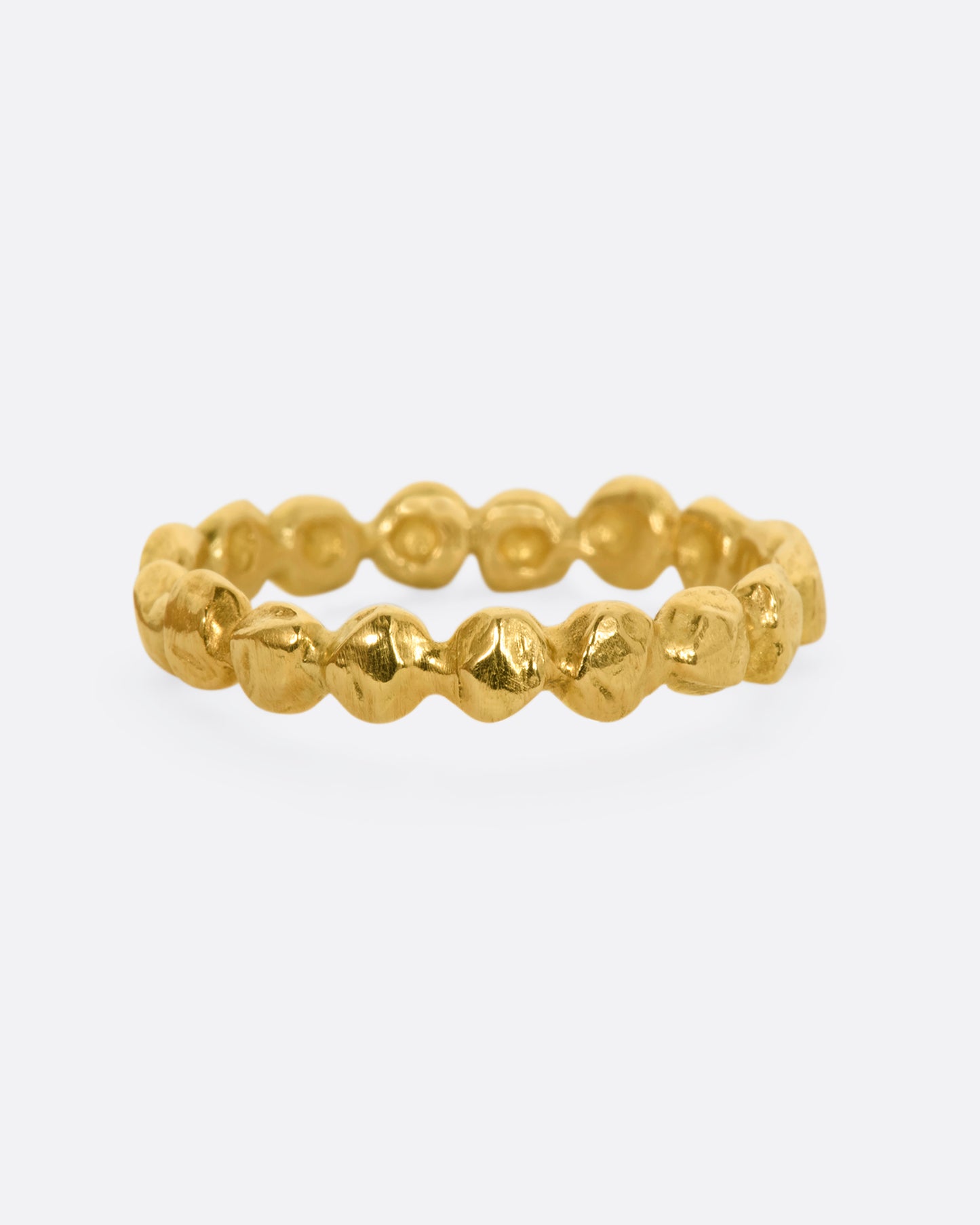 A yellow gold textured dot eternity band.