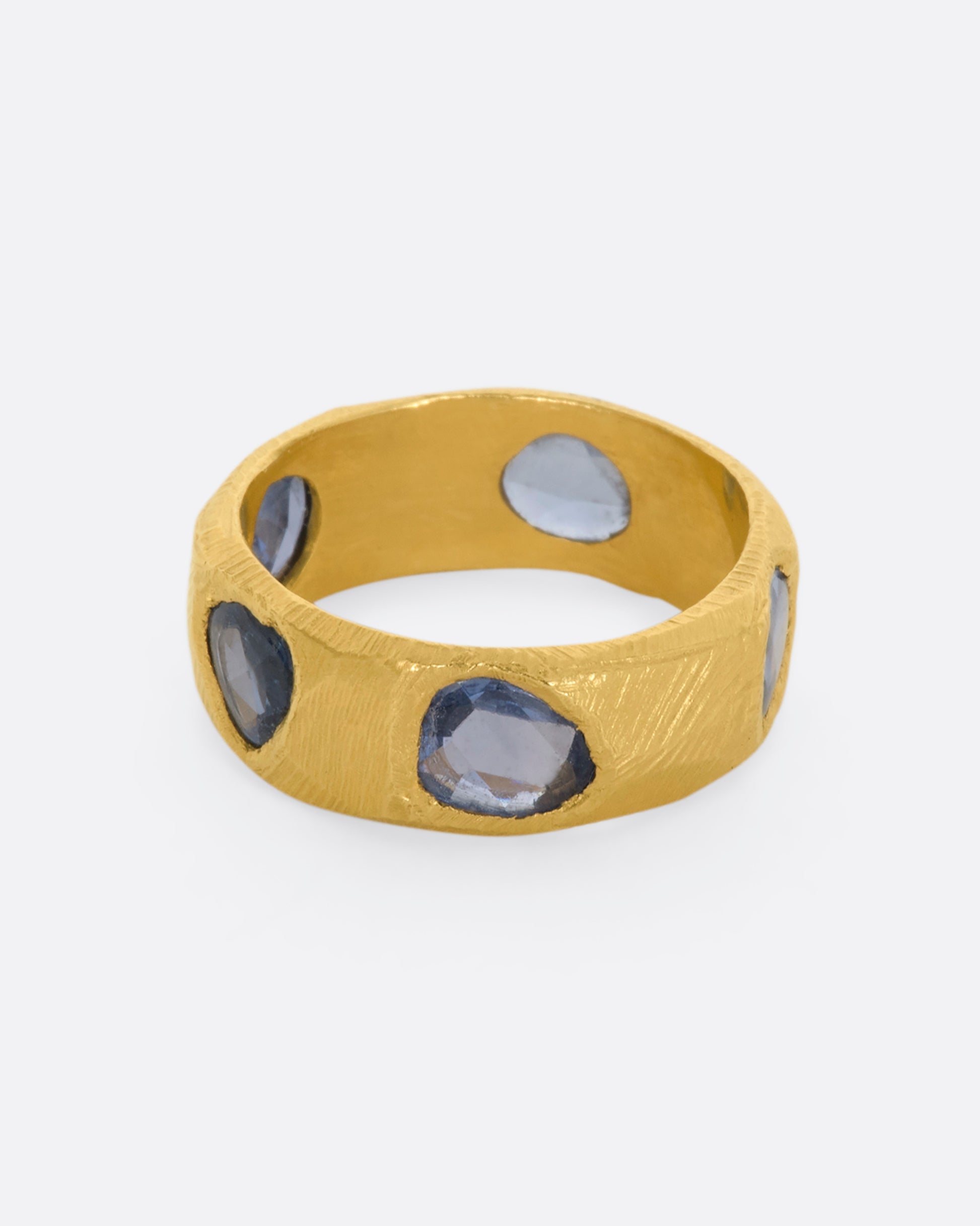 A yellow gold ring with five large blue rose cut sapphires.