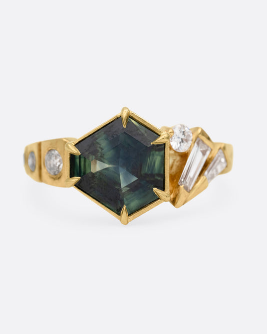 A yellow gold ring with a prong set Australian sapphire and white diamonds shown from the front.