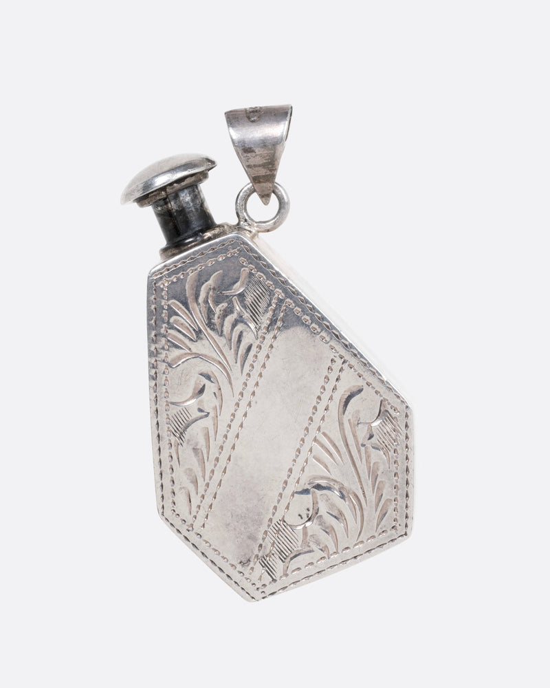 A silver perfume bottle with botanical etchings, a twist- off wand, and a bail, shown from the front.